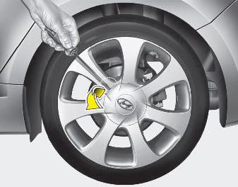Hyundai Elantra: Changing tires. 6. Insert the screwdriver into the groove of the wheel cap and pry gently to