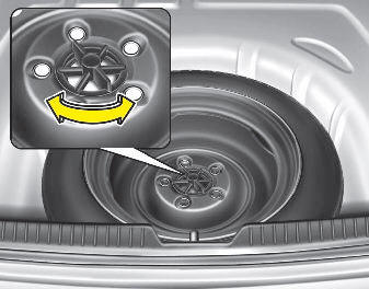 Hyundai Elantra: Removing and storing the spare tire. Turn the tire hold-down wing bolt counterclockwise.